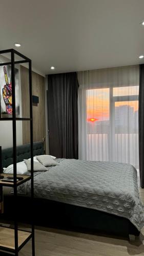 a bedroom with a bed and a window at HERMES Cityview Apartment in Chişinău