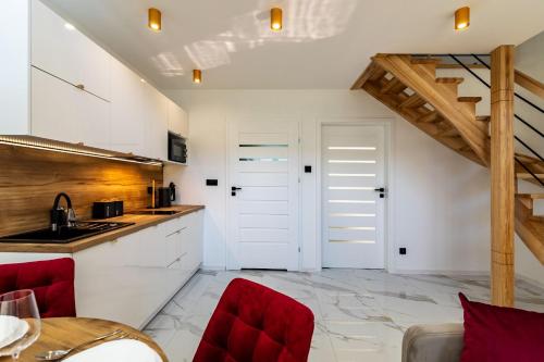 a kitchen with white cabinets and red chairs at Hotel Perła Dunajca in Czarny Dunajec