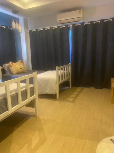 a bedroom with a white bed and a black curtain at Sleep Eat Here at donmuang in Ban Chek
