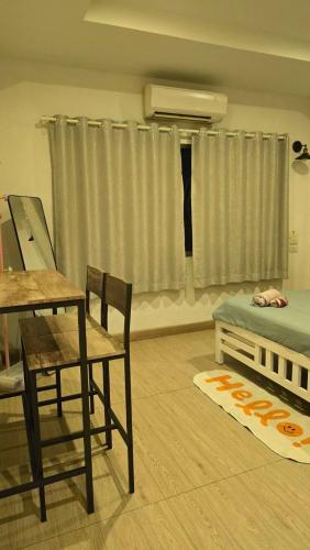 a living room with a bed and a table and chairs at Sleep Eat Here at donmuang in Ban Chek