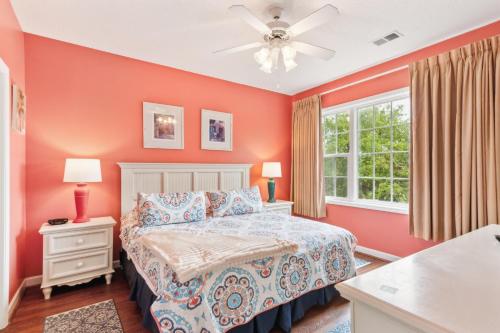 a bedroom with red walls and a bed and a window at Havens on the Nine condo in North Myrtle Beach
