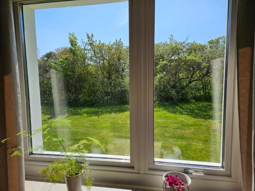 a window with a view of a field of grass at Strandvillan i Slite in Slite