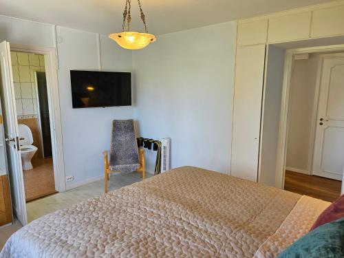 a bedroom with a bed and a chair and a tv at Strandvillan i Slite in Slite