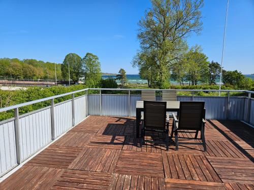 a wooden deck with a table and chairs on it at Strandvillan i Slite in Slite