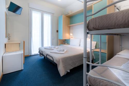a hotel room with two bunk beds and a television at Hotel & Residence Parador in Cesenatico