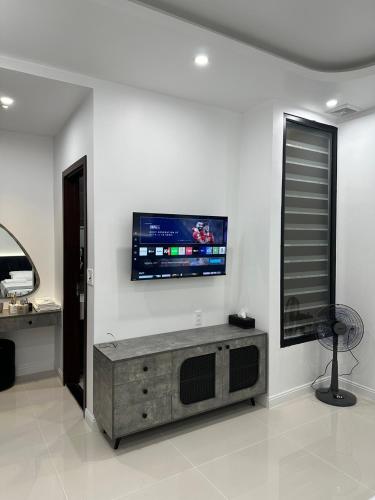 a living room with a tv on a white wall at Sunny Hotel in Ðố Sơn