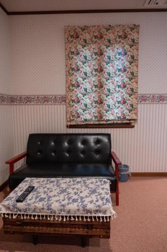 a couch in a room with a painting on the wall at Pension Balmy in Nasu