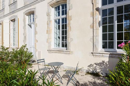 une table et des chaises devant un bâtiment dans l'établissement Appartement avec jardin dans un château, à Lagord