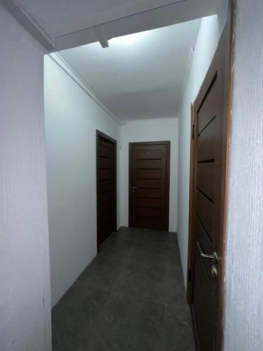 an empty room with two doors and a hallway at Room Hostel Tolebi in Almaty