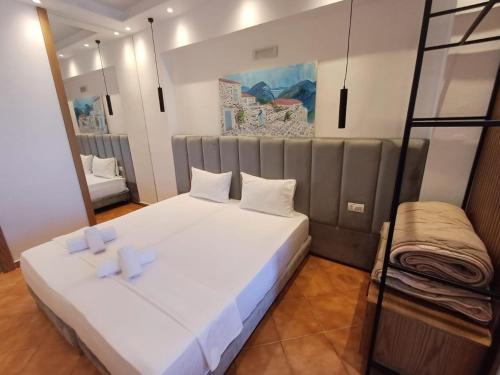 a bedroom with a large white bed with two pillows at Velco BB Himara in Himare
