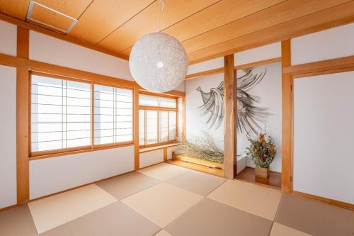 a room with windows and a pendant light at Third Place Nagano in Matsumoto