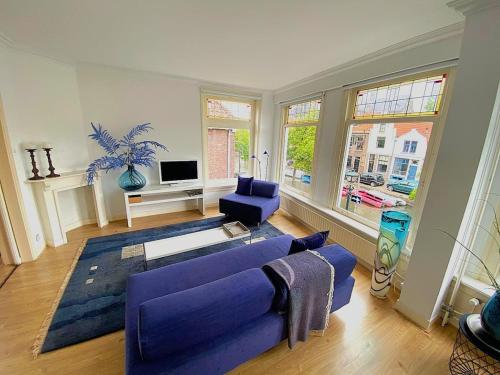 a living room with a purple couch and a tv at Verdronkenoord57 in Alkmaar