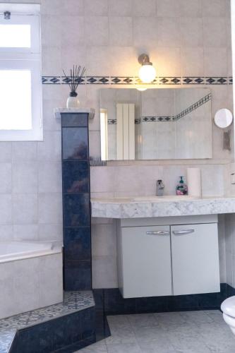 a bathroom with a sink and a tub and a mirror at Verdronkenoord57 in Alkmaar