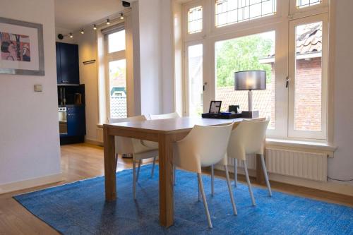 a dining room with a wooden table and white chairs at Verdronkenoord57 in Alkmaar
