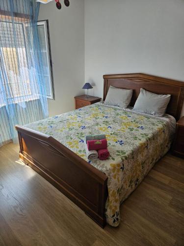 a bedroom with a large bed with a flowery blanket at BigWaves2 in Nazaré