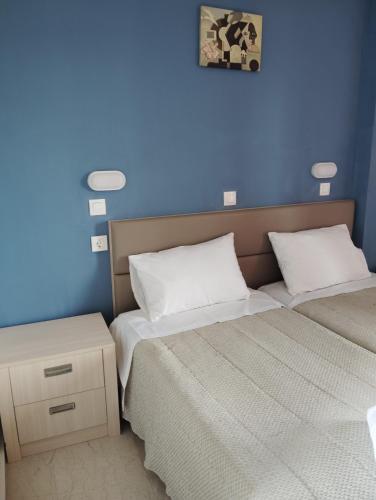 zwei Betten in einem Zimmer mit blauer Wand in der Unterkunft Kavos Fantasia Complex in Kavos