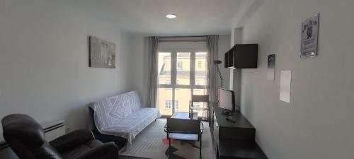 a living room with a couch chair and a television at Alojamiento Misericordia in Viveiro