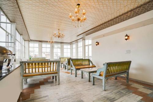 a row of benches in a room with windows at Townhouse Oak Durgapura Railway Junction in Jaipur