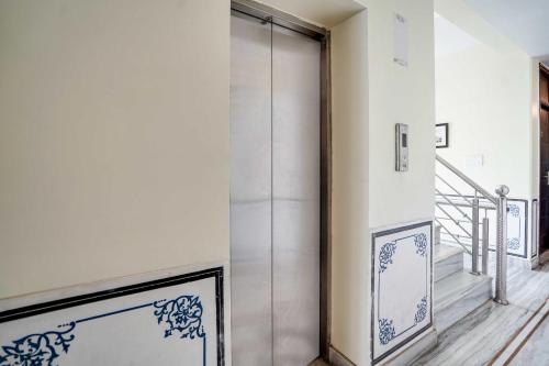 a glass door in a room with a staircase at Townhouse Oak Durgapura Railway Junction in Jaipur
