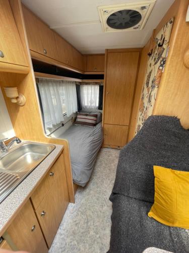 ein kleines Zimmer mit einem Bett und einem Waschbecken in der Unterkunft The Cosy Camper at Rockfield Park in Galway