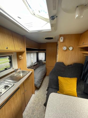 eine kleine Küche mit Spüle und ein Schlafzimmer in der Unterkunft The Cosy Camper at Rockfield Park in Galway
