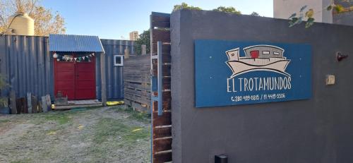 a sign on the side of a fence with a building at El Trotamundos in Puerto Pirámides