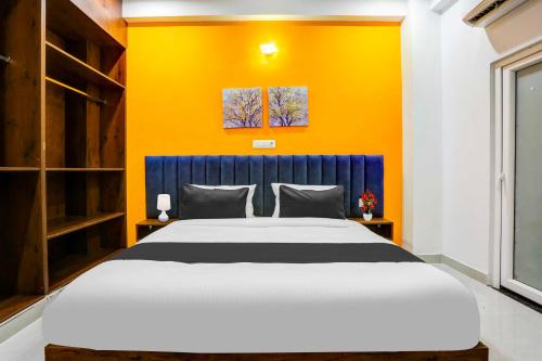 a bedroom with a large bed and a yellow wall at Townhouse Oak Sector 69 Gurgaon in Gurgaon