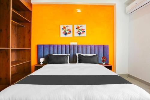 a bedroom with a large bed with a blue headboard at Townhouse Oak Sector 69 Gurgaon in Gurgaon