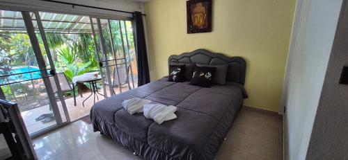 a bedroom with a large bed and a balcony at Palmgarden Resort Samui - only Adult - neu Saniert in Ban Tai