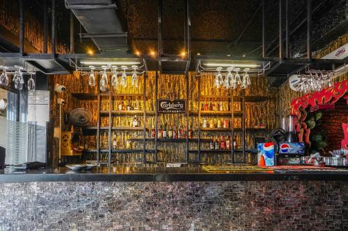 a bar with a bunch of alcohol on the wall at Townhouse Oak Kota Airport in Kota