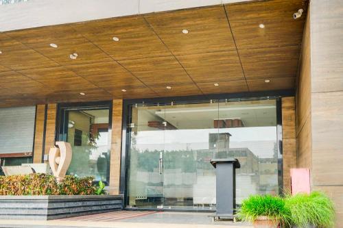 a glass entrance to a building with a wooden ceiling at Townhouse Oak Kota Airport in Kota