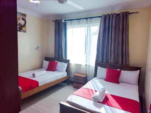 a bedroom with two beds and a window at Two-Bedroom Deluxe Apartment with Ocean View in Mombasa