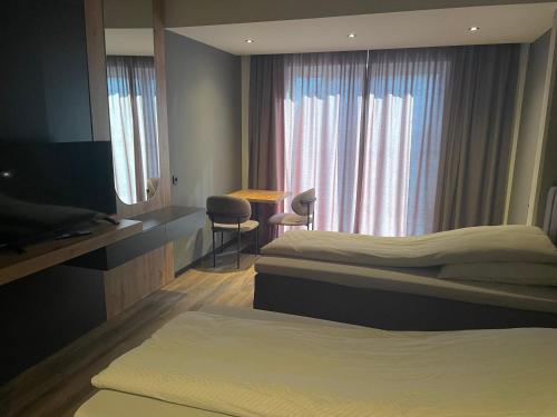 a hotel room with two beds and a window at A & B Apartment und -Zimmervermietung in Tornesch