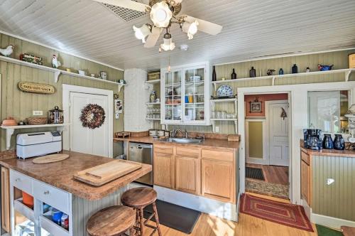 a kitchen with wooden cabinets and a ceiling fan at 10 Mi to Gore Mountain- Home in Adirondack Park home in Olmstedville