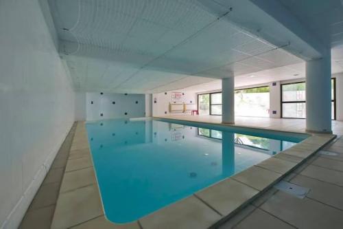 une grande piscine avec de l'eau bleue dans un immeuble dans l'établissement Uzès centre à 2 min - piscine - clim - parking, à Uzès