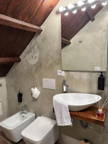 a bathroom with a sink and a toilet and a mirror at Dimora fontanese in Ferrara