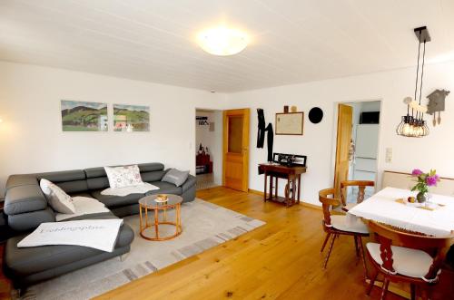 a living room with a couch and a table at Gemütliche Fewo mit Sonnenterrasse in Bernau im Schwarzwald