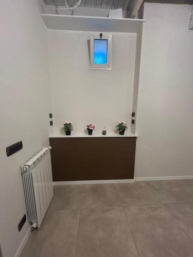 a white room with potted plants and a window at Bed & Breakfast La Rosa in Rome