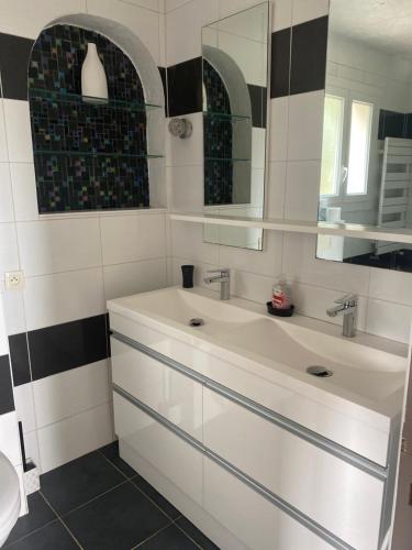 une salle de bain avec deux lavabos et un miroir dans l'établissement Bastide Anna, au Cannet