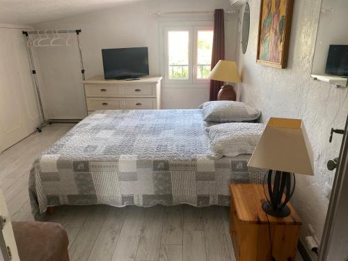 une chambre avec un grand lit et une télévision dans l'établissement Bastide Anna, au Cannet