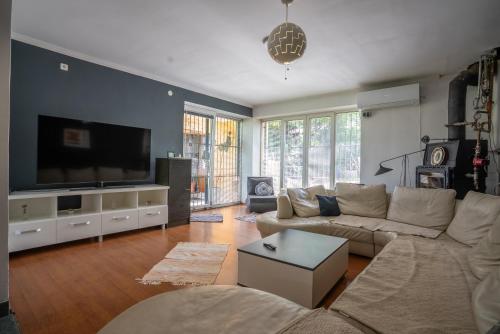 a living room with a couch and a flat screen tv at Capital Stay in Sarajevo