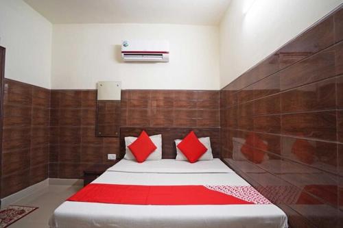 Un dormitorio con una cama grande con almohadas rojas. en Rainbow Inn, en Nueva Delhi