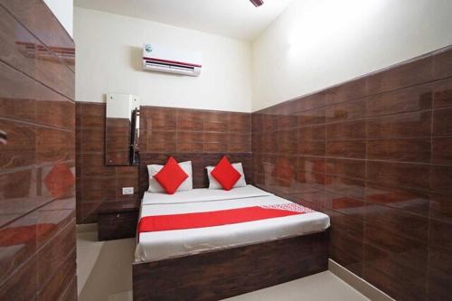 Un dormitorio con una cama con almohadas rojas. en Rainbow Inn, en Nueva Delhi