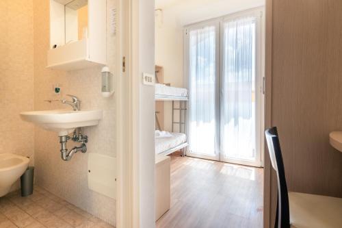 a bathroom with a sink and a toilet and a window at Hotel & Residence Parador in Cesenatico