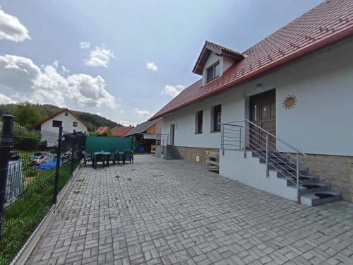 a patio of a white house with a fence at Guest House Mengsdorf in Mengusovce