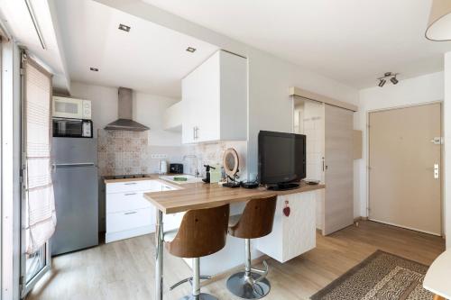 une cuisine avec une table en bois et une télévision. dans l'établissement Studio Wilson - Centre Ville - Terrasse & Parking, à La Celle-sous-Gouzon