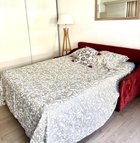 - une chambre avec un lit doté d'un couvre-lit blanc et d'un miroir dans l'établissement Studio Wilson - Centre Ville - Terrasse & Parking, à La Celle-sous-Gouzon