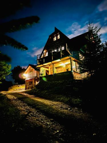 a large house on a hill at night at Mountain story apartment in Žabljak