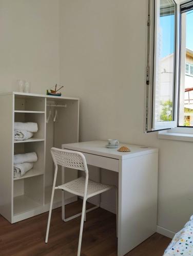 a white desk and chair in a room with a window at Sobe Tramontana in Murter