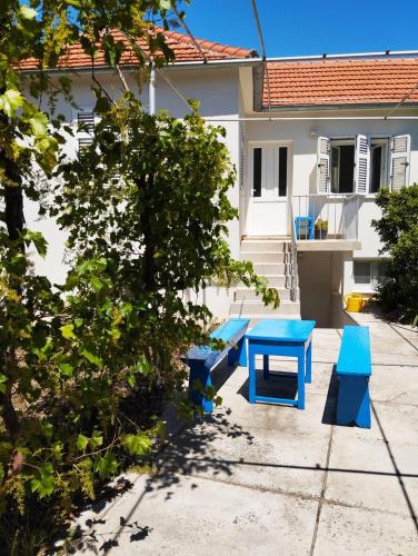 a blue table and benches in front of a house at Sobe Tramontana in Murter
